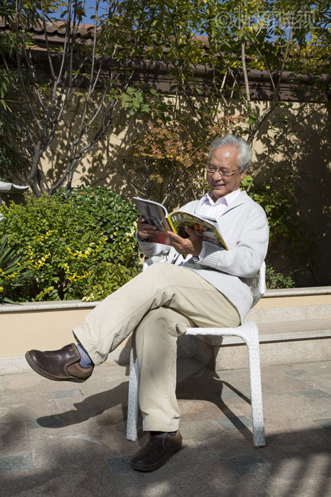 老年男人在院子里看书