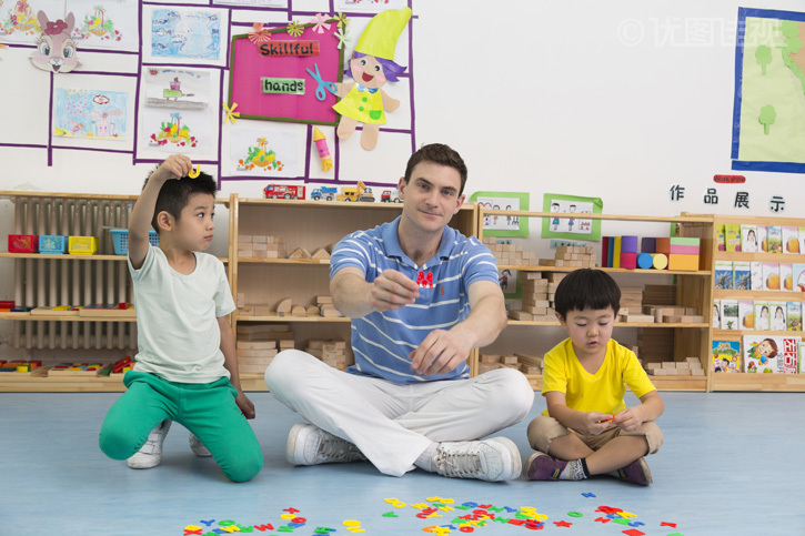 幼儿园外教男老师和儿童一起玩字母游戏